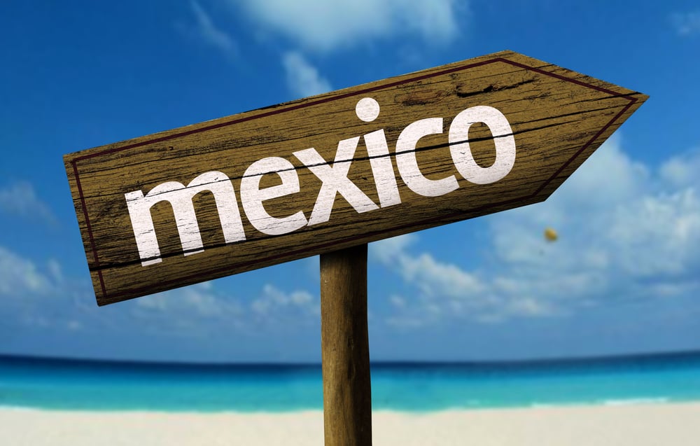 Mexico wooden sign with a beach on background